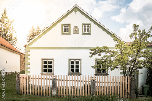 Beautiful romantic cottage in European village, Repaired historic house with wooden fence background, Symbol of classical and modern life in village