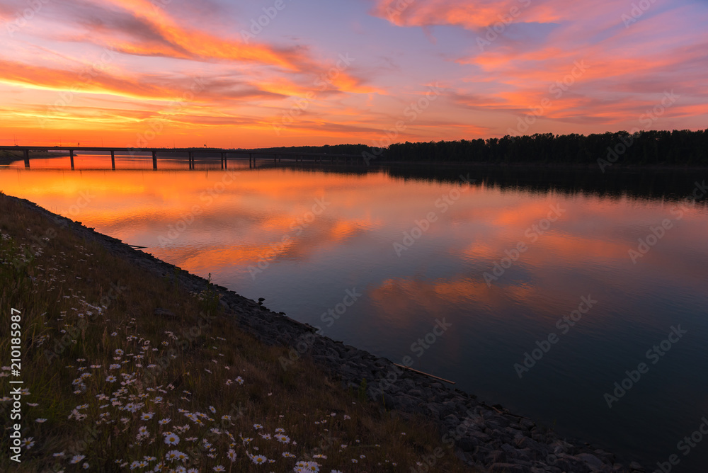 Colorful summer sunsets over a glassy smooth river