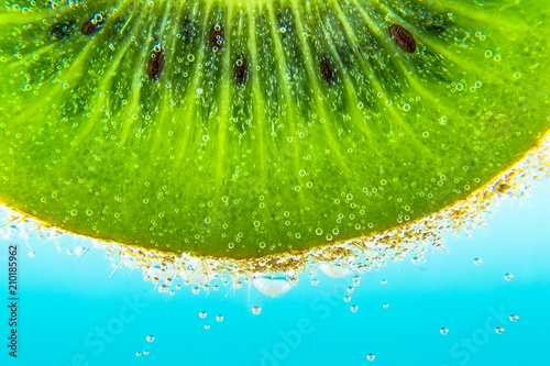 Kiwi water bubbles blue light background texture close-up macro. Bright view photo.