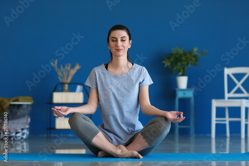 Young woman practicing yoga...