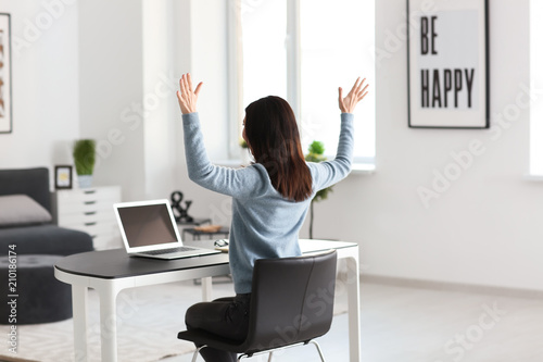 Happy female freelancer working with laptop in office