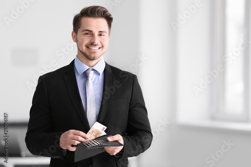 Young businessman counting ...