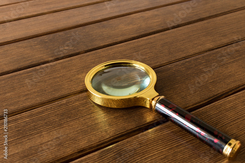 Magnifying glass on wooden table. Search concept