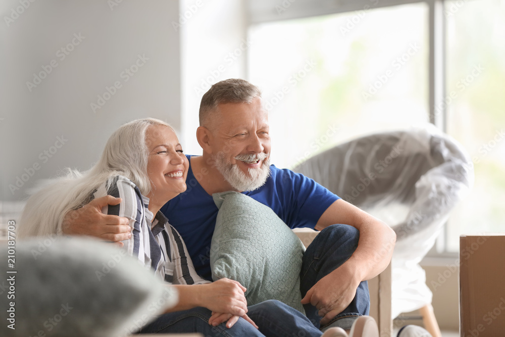 Fototapeta premium Mature couple with belongings indoors. Moving into new house