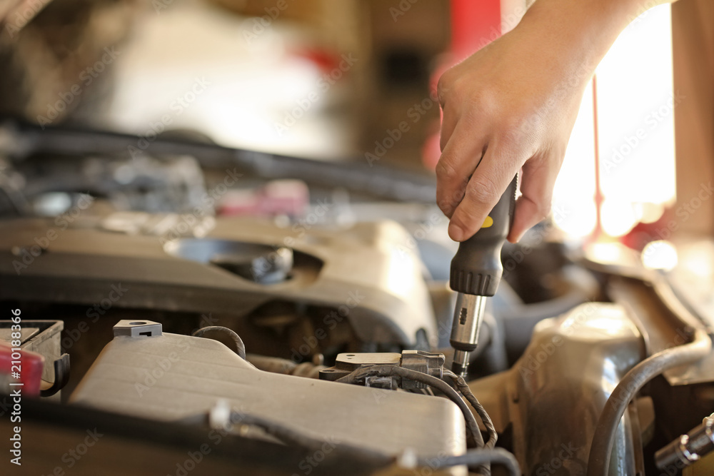 Auto mechanic repairing car in service center, closeup Auto mechanic repairing car in service center, closeup