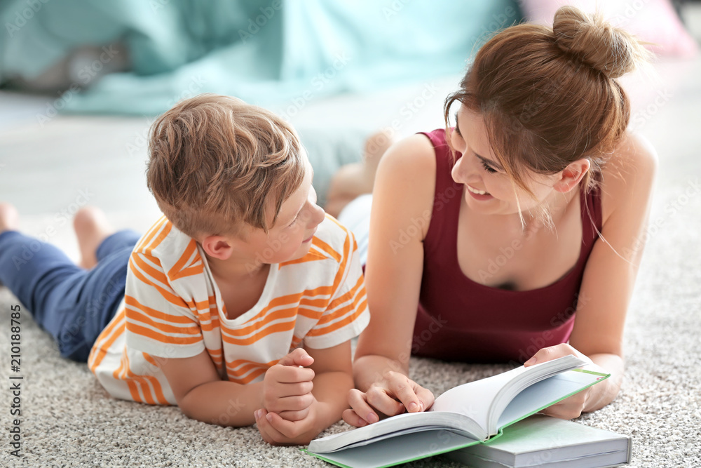 Mother and her son reading book together at home