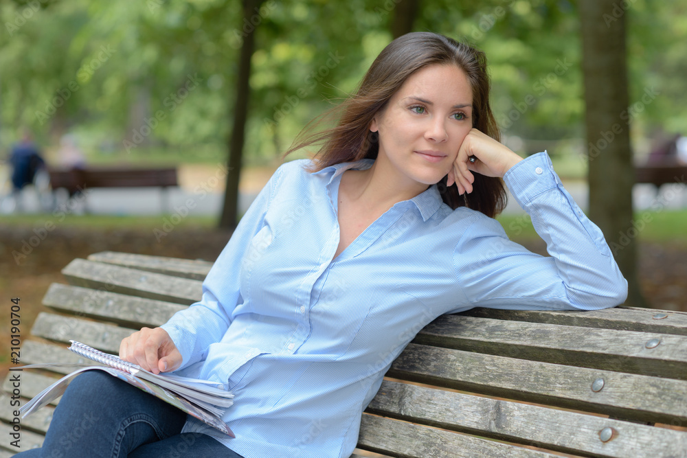 female writer sitting on the park bench female writer sitting on the park bench