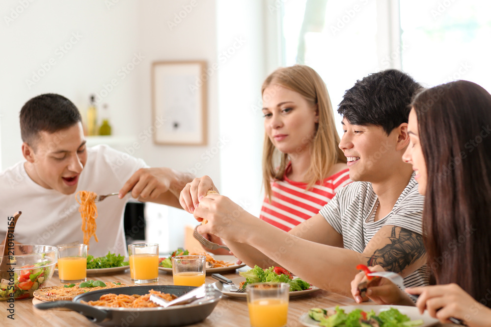 Friends eating at table in kitchen Friends eating at table in kitchen