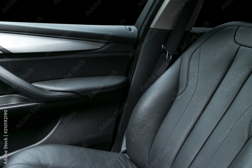Modern Luxury car inside. Interior of prestige modern car. Comfortable leather Black seats. Black  perforated leather cockpit with isolated Black background. Modern car interior details. Car detailing