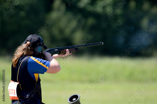 Teenage girl shooting in a shotgun competition.