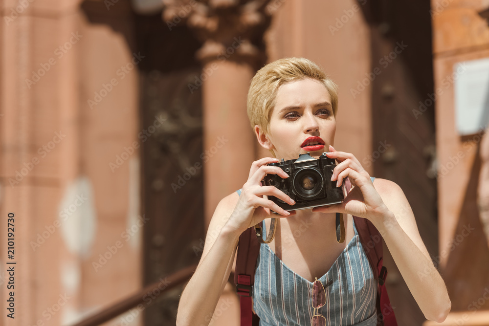 beautiful girl taking photo on camera in city