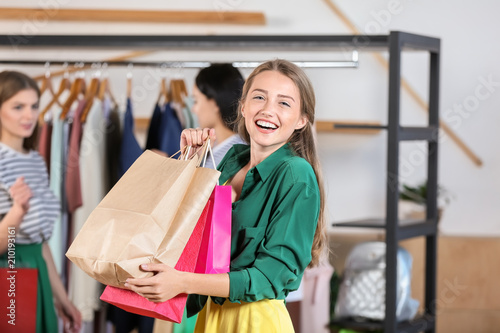 Young beautiful woman with shopping bags in clothing shop