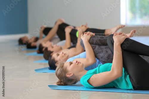 Group of people practicing yoga in gym