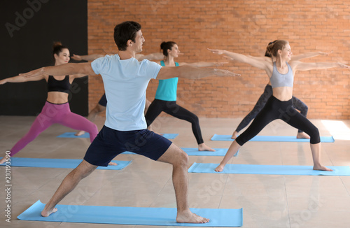 Group of people practicing yoga in gym