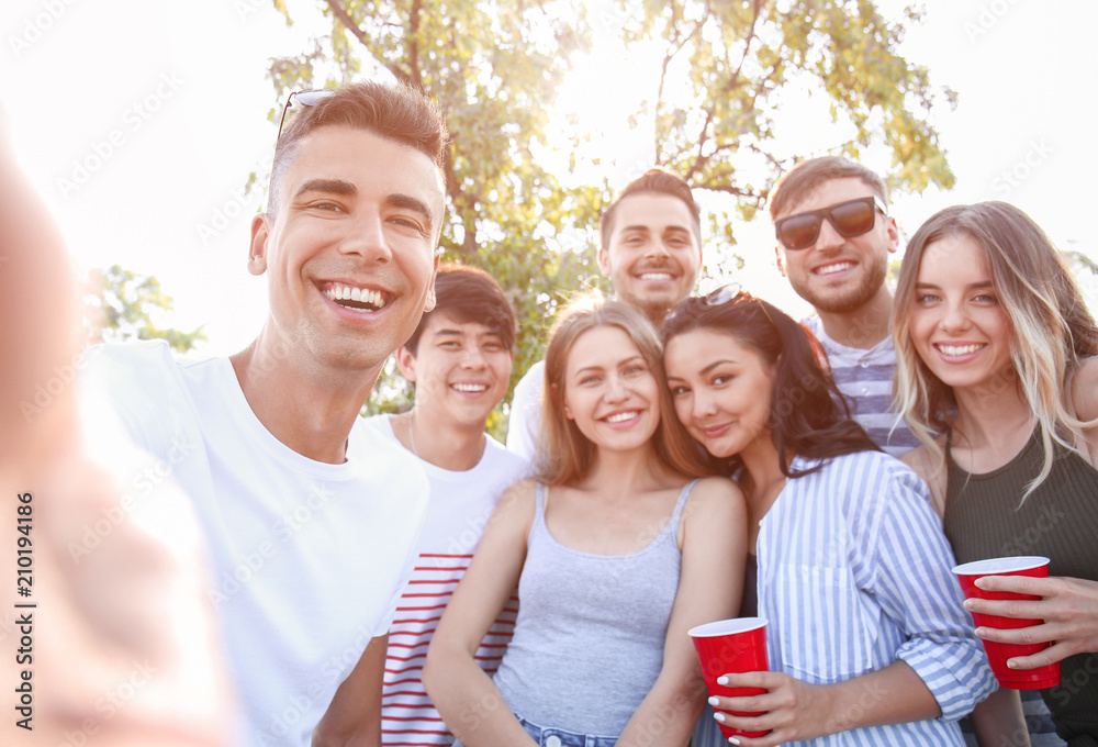 Obraz premium Group of attractive young people taking selfie outdoors