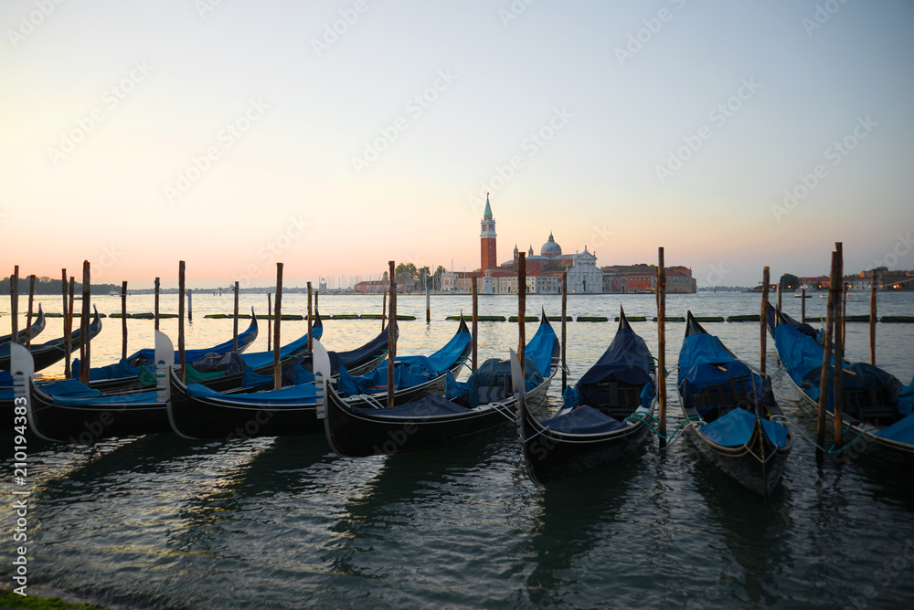 Venetian gondolas in the background of the San Marco bay at sunrise Venice, Italy