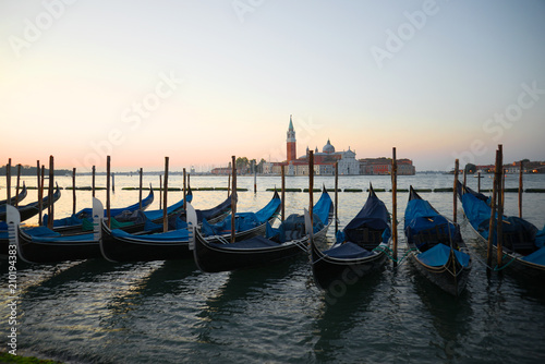 Venetian gondolas in the background of the San Marco bay at sunrise Venice, Italy © sikaraha