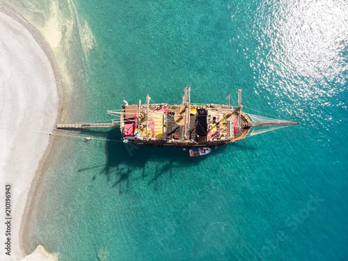 Obraz Antena nad żeglowanie statkiem w turkus wodzie na jaskrawym dniu w Oludeniz, Turcja