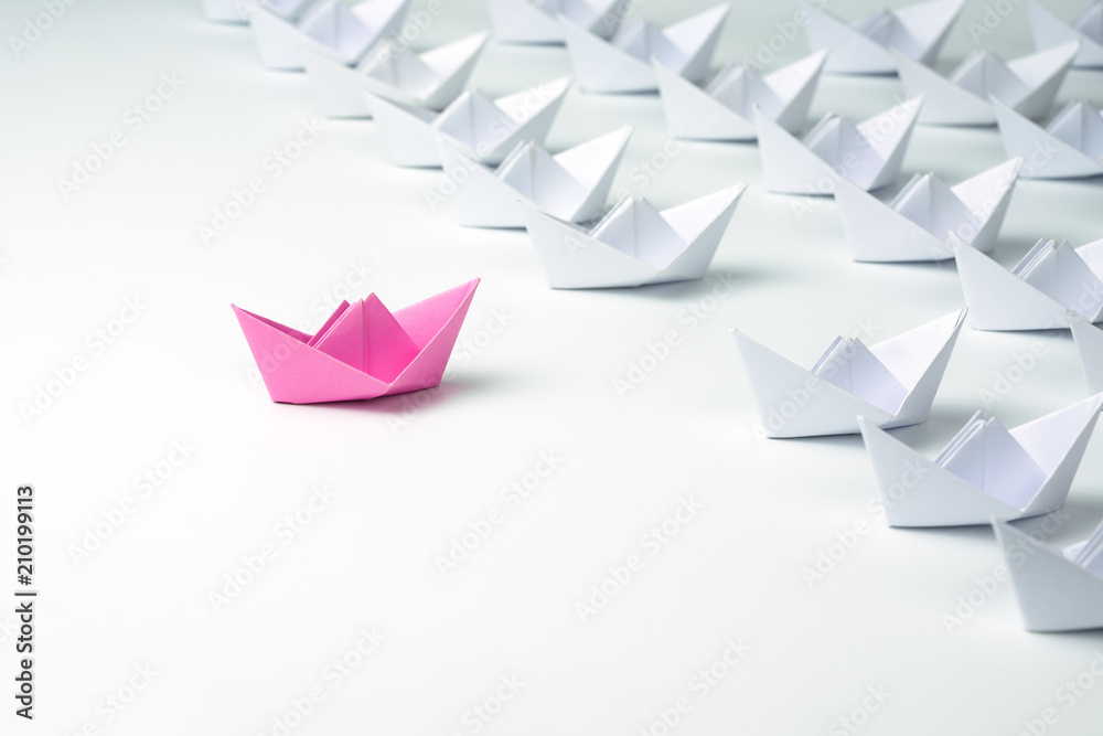 Woman leadership concept with pink paper ship.