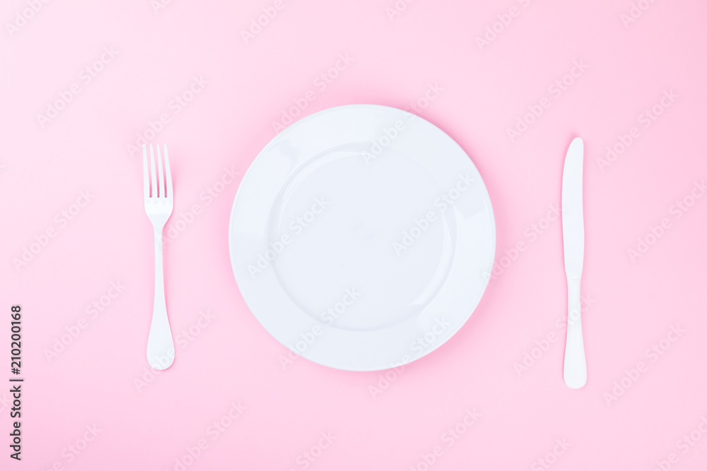 Concept minimal .Time to Eat. Fork, knife and white Plate on a pink pastel Background. Top View. Flat Lay. Copy space for Text. Concept minimal .Time to Eat. Fork, knife and white Plate on a pink pastel Background. Top View. Flat Lay. Copy space for Text.