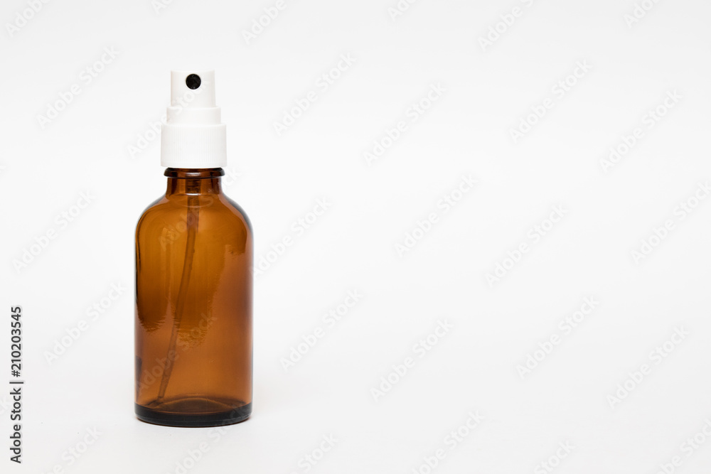 A brown bottle for essential oils and cosmetic products. Glass bottle on white background. A dropper, a bottle with a sprayer, a jar. Mockup isolated on white