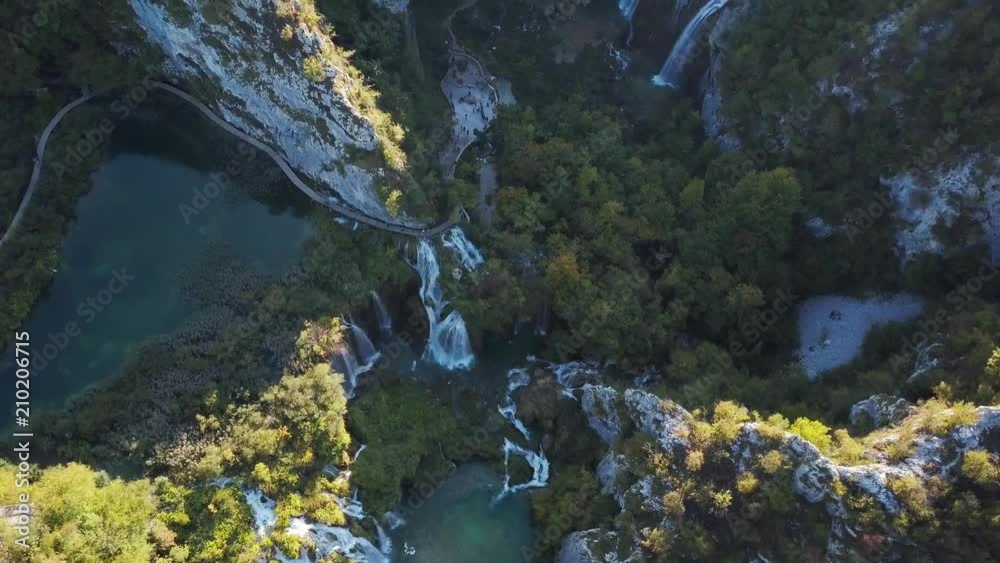 Plitvice Lakes National Park, Croatia aerial view. Flying over waterfalls and beautiful forest scenery near sunset. 4k drone footage looking down at waterfalls and rivers.