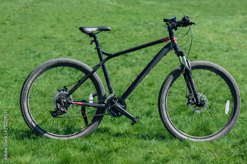 Closeup of sportive bicycle on green grass meadow background