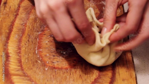 Women prepare vak belyash - bashkir national homemade meat pies , close up shot. Meat and potato inside, dough is twisted. Cooking at home. photo