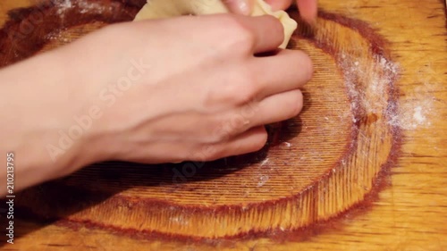 Raw Vak belyash - bashkir national homemade meat pies on wood chopping board at home kitchen. Preparation making from raw dough process. photo