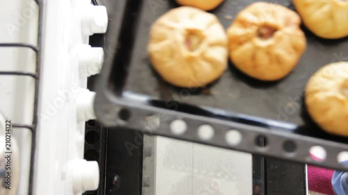 Women opens oven and take off prepared hot vak belyash - bashkir national homemade meat pies. Top view. photo