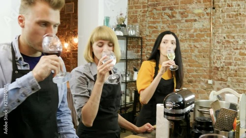 Men and women clinking glasses of red and white wine and drinking it on cooking master class. 4K