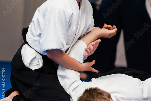 Aikidoka uses the technique joint lockon the opponent during the training of aikido photo