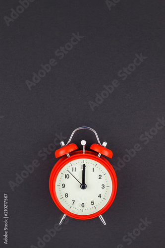 Red vintage alarm clock on dark background