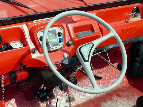 Spartanisches rotes Interieur mit Zweispeichenlenkrad eines französischen Geländewagen der Siebzigerjahre im Sommer in Lage bei Detmold am Teutoburger Wald in Ostwestfalen-Lippe