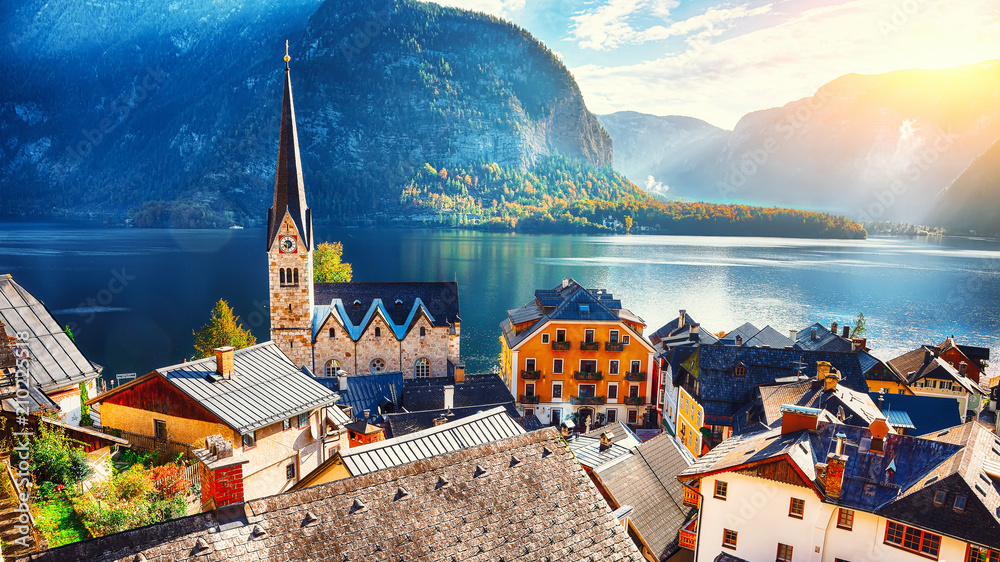 Fototapeta premium Scenic view of famous Hallstatt mountain village with Hallstatter lake See in beautiful golden morning light in fall
