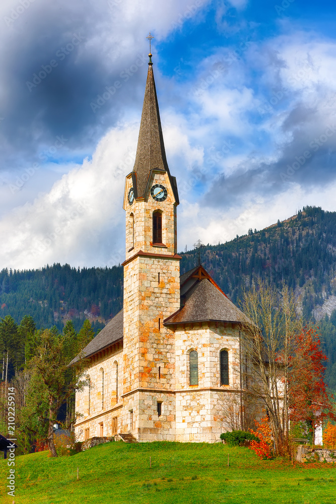 Mountains over Gosau village with Catholic Church under Sunlight.