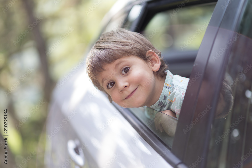 little boy with head leaned through the open window of a car little boy with head leaned through the open window of a car