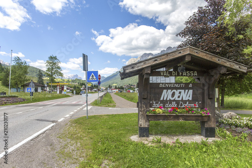 Moena, Trentino Alto Adige, Dolomites, Alps, Italy - June 19, 2018: Beautiful view of the town of Moena in the Dolomite mountains, Italy. Old town in the Italian Alps. Welcome to Moena. photo