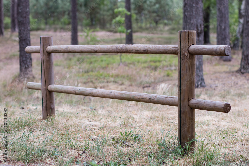 A wooden fence in a parking space for cars. Wooden fence for a place of rest for drivers. A wooden fence in a parking space for cars. Wooden fence for a place of rest for drivers.