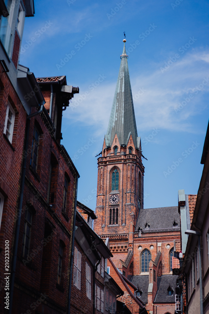 Fototapeta premium Traditional facades and roofs, Gothic Cathedral church in the historic centre of Luneburg, Germany