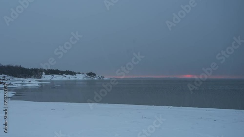 Timelapse of sunrise during light snow on snowy beach in Hanko, Finland