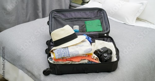4K stop motion animation of empty suitcase being filled up with women's clothes