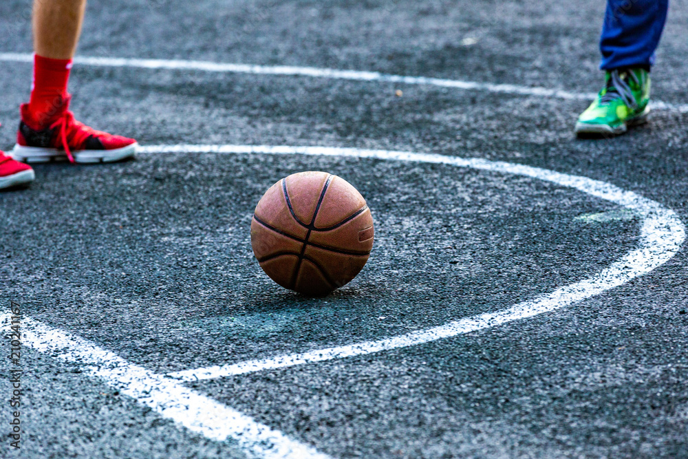 Basketball ball in the outdoors court lying on the ground Basketball ball in the outdoors court lying on the ground