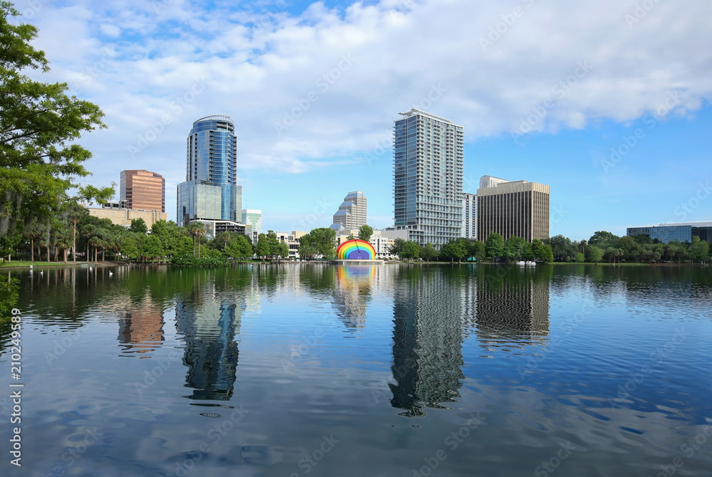 Downtown Orlando skyline glistens as it reflects in the clean waters of Lake Eola.   Lake Eola Park is a popular downtown tourist attraction.