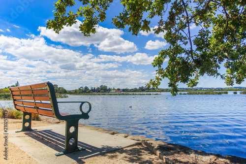 Fototapeta Naklejka Na Ścianę i Meble -  Bench seat by the lake against beautiful blue sky on a bright summer day. Lake Wendouree, Ballarat, VIC Australia.