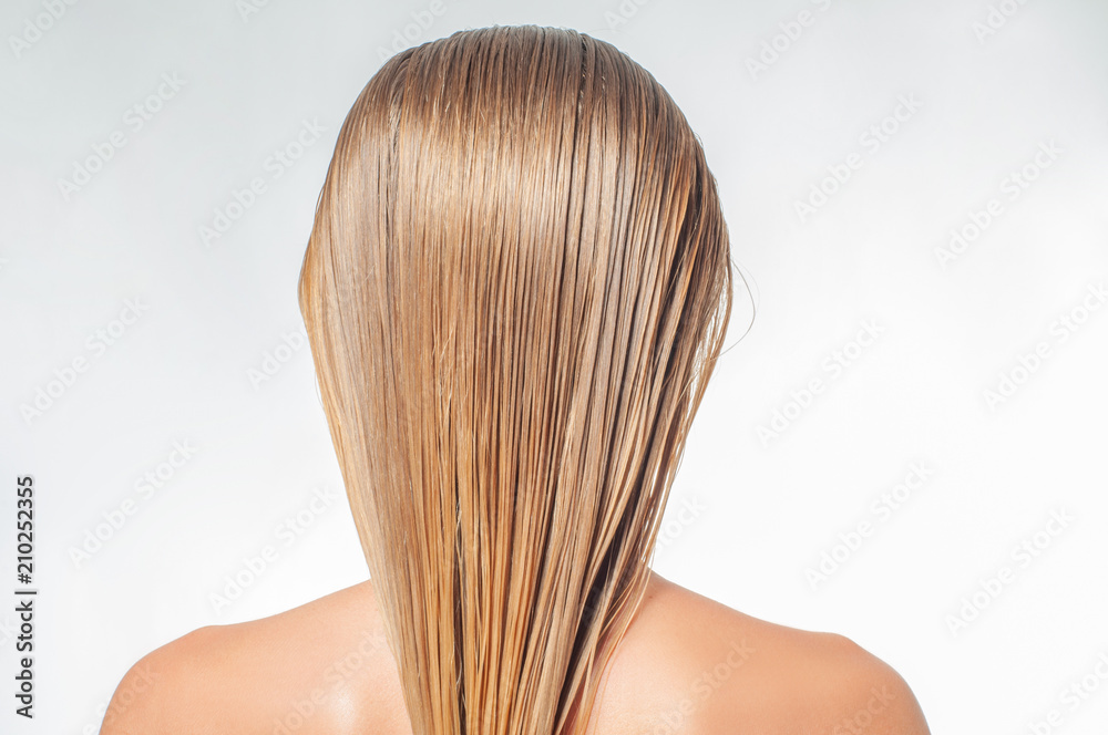 Naklejka premium Blond woman with long wet hair is applying hair conditioner
