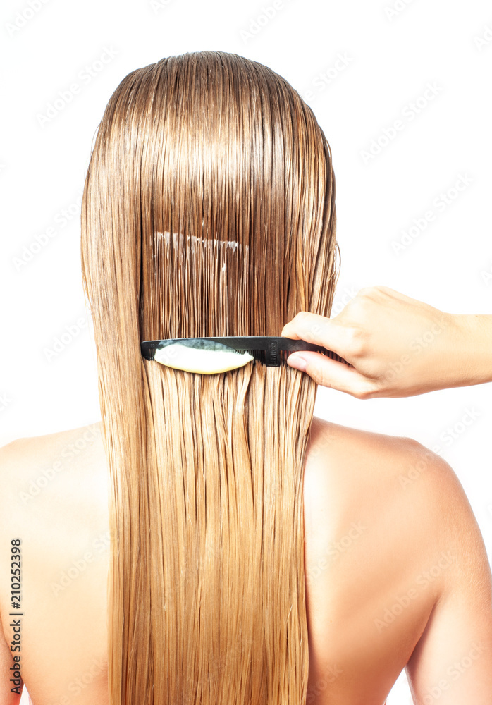 Woman with comb is applying hair conditioner on her wet blonde hair Stock  Photo | Adobe Stock