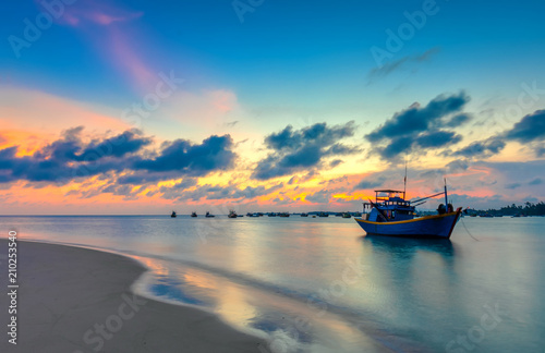 Φωτογραφία Sunset and boat on the sea as the sun slowly down the horizon circle creates a beautiful golden light on the bay