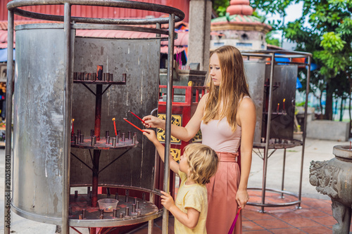 Incense sticks on joss stick pot are burning and smoke use for pay respect to the Buddha, Incense sticks in Mother and son hand and smoke use for pray respect to the Buddha in Buddhism life