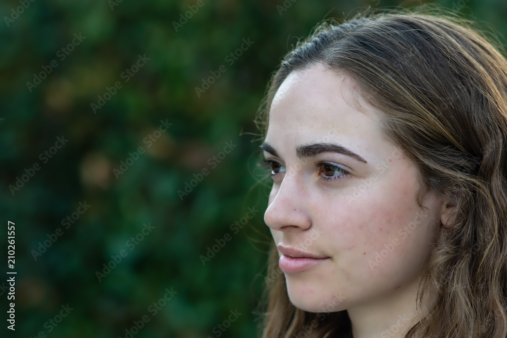 Side view close-up of young woman outdoors in natural light Side view close-up of young woman outdoors in natural light